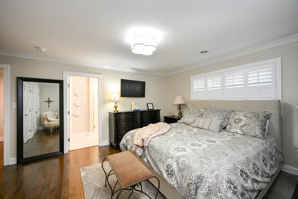 a large bedroom with a bed and wooden floor