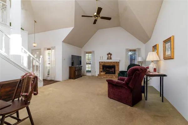 a living room with furniture a fireplace and a chandelier