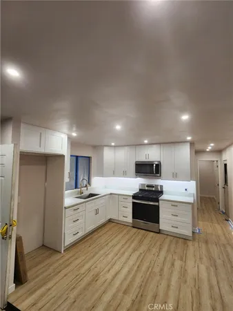 a kitchen with granite countertop a refrigerator and a stove top oven