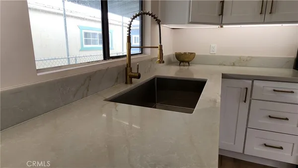 a kitchen with a sink and a mirror