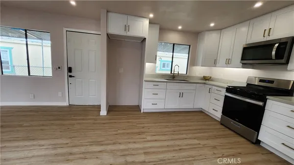 a large kitchen with stainless steel appliances granite countertop a stove a sink and a refrigerator