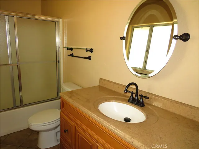 a bathroom with a sink a toilet and shower a mirror