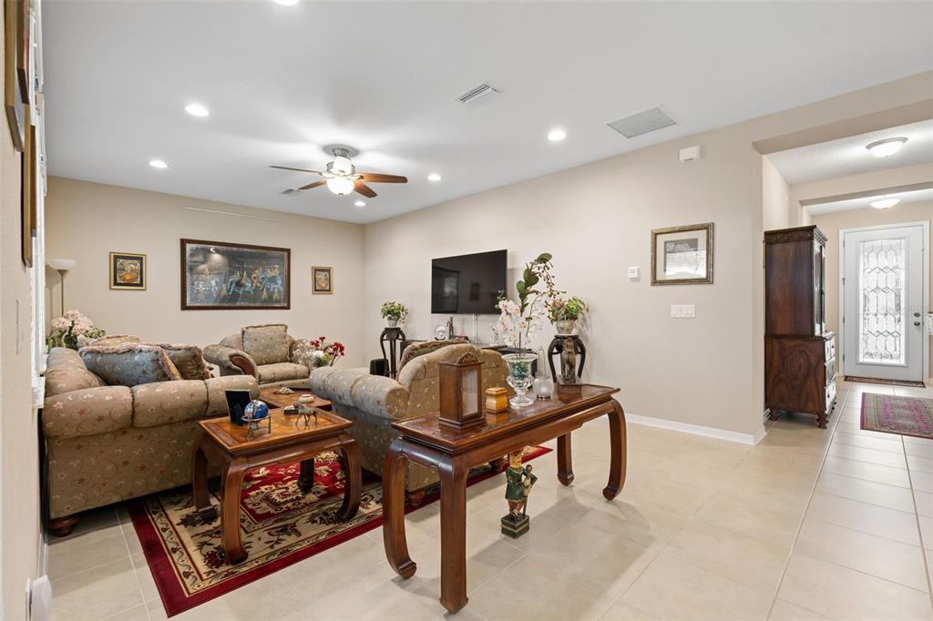 31046 Parrot Reef Court Wesley Chapel, FL 33545 - Photo 24 of 99 a living room with furniture and a flat screen tv
