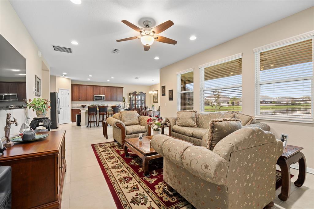31046 Parrot Reef Court Wesley Chapel, FL 33545 - Photo 26 of 99 a living room with furniture kitchen area and a large window
