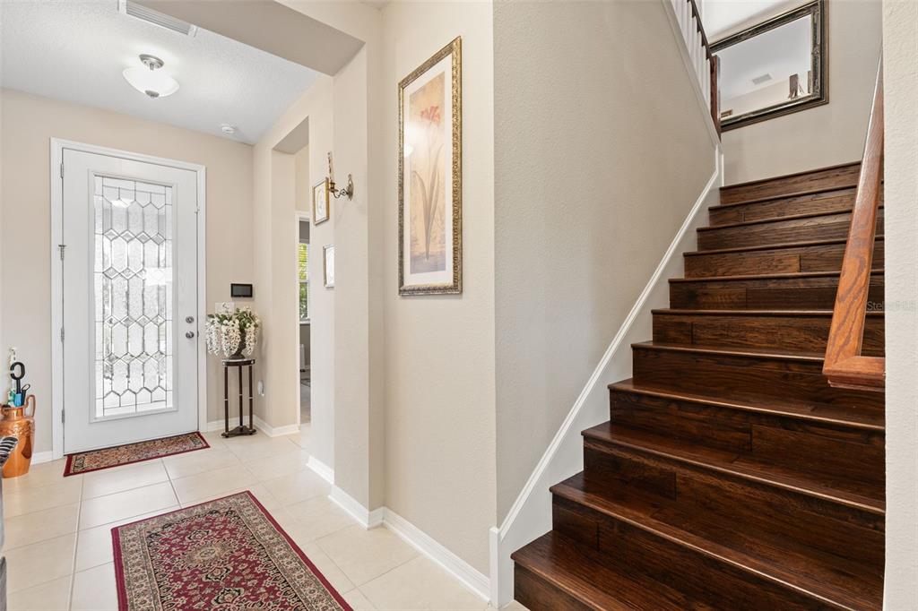 31046 Parrot Reef Court Wesley Chapel, FL 33545 - Photo 27 of 99 a view of entryway with wooden floor and stairs