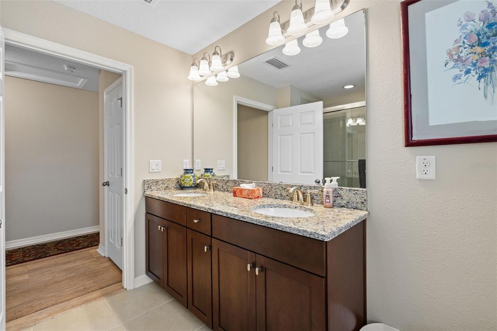 31046 Parrot Reef Court Wesley Chapel, FL 33545 - Photo 46 of 99 a bathroom with a double vanity sink and a mirror