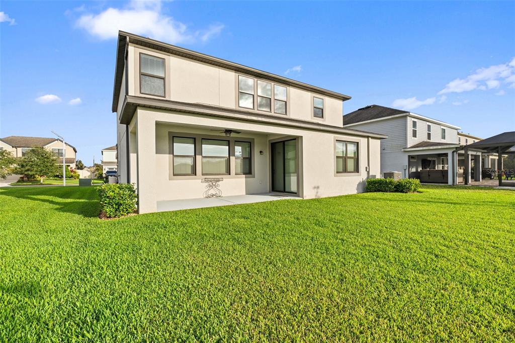 31046 Parrot Reef Court Wesley Chapel, FL 33545 - Photo 56 of 99 a view of a white house with a big yard and potted plants
