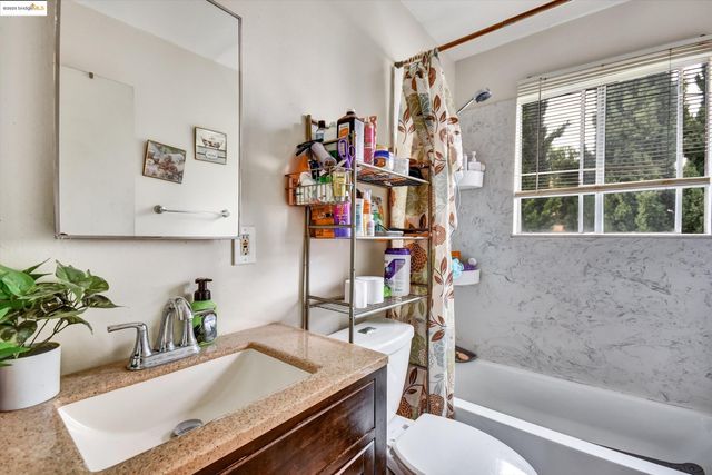 a bathroom with a granite countertop sink a toilet and shower