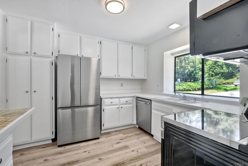 4135 Pinehurst Court Fallbrook, CA 92028 - Photo 12 of 25 a kitchen with a refrigerator a sink and cabinets