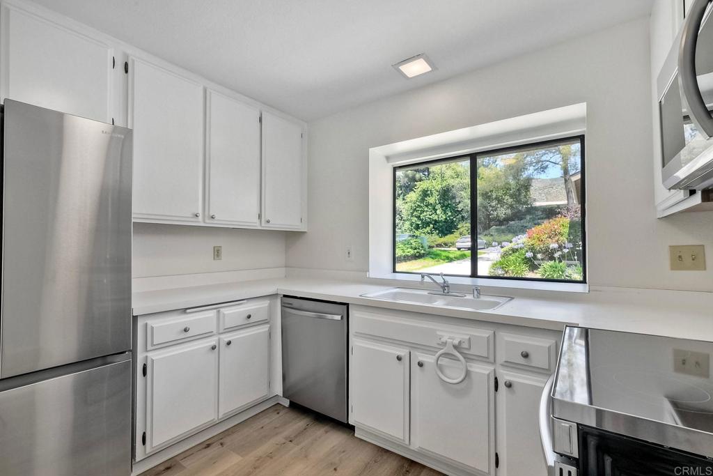 4135 Pinehurst Court Fallbrook, CA 92028 - Photo 14 of 25 a kitchen with white cabinets white appliances and a window