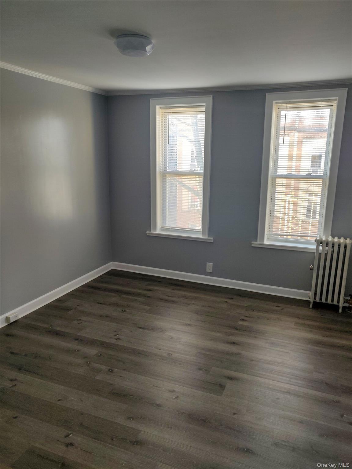 41-43 49th Street Queens, NY 11104 - Photo 3 of 6 an empty room with wooden floor and windows
