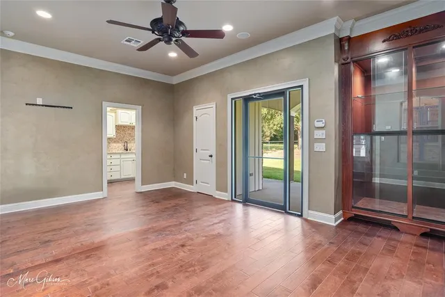 an empty room with fan and windows