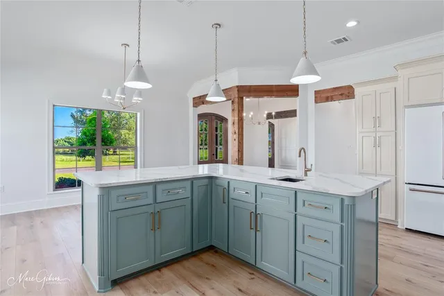 a kitchen with kitchen island a sink stove and wooden floor