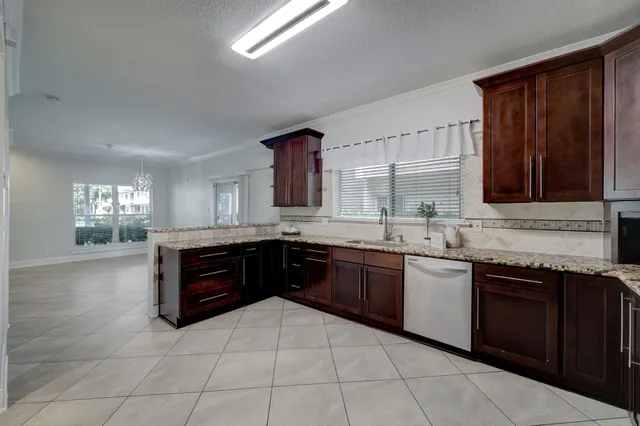 a large kitchen with granite countertop a stove sink and cabinets