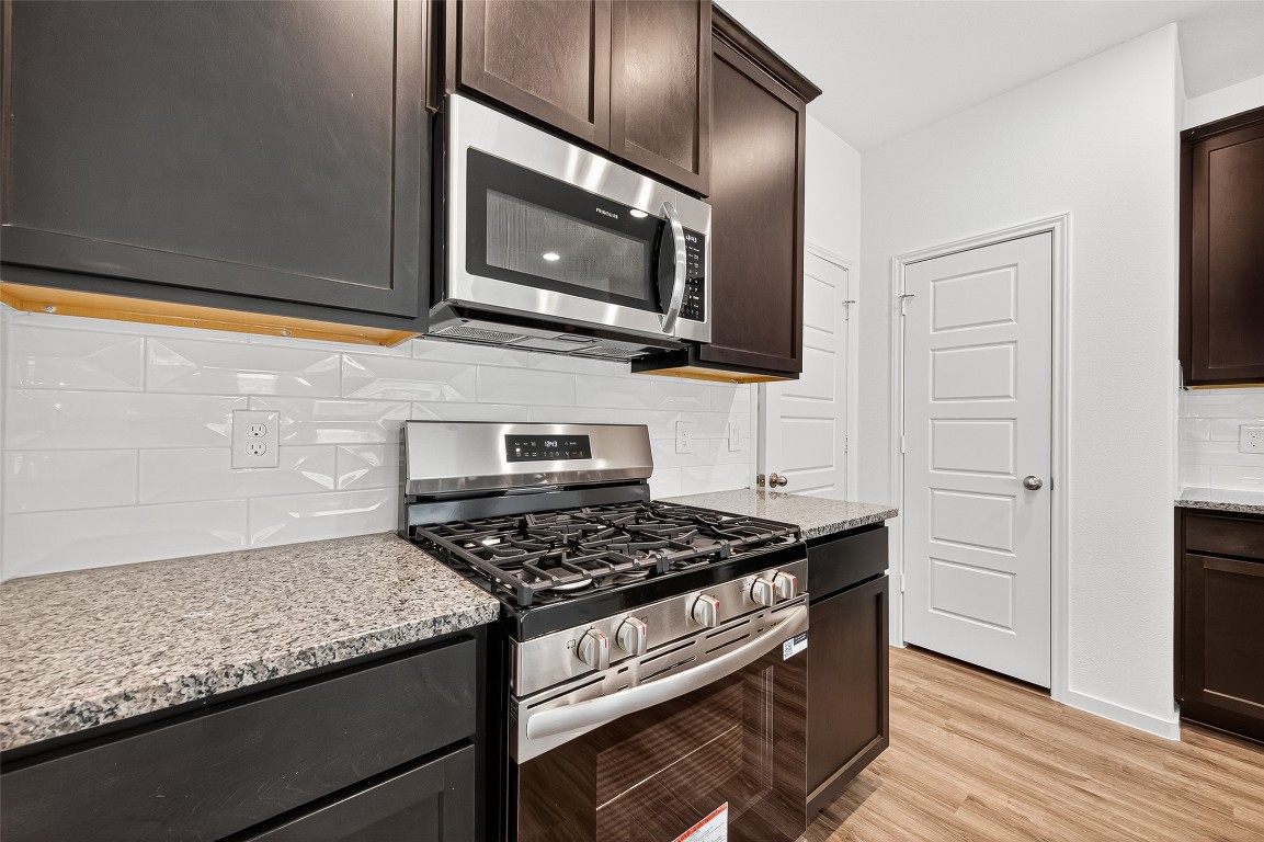 20835 Attalos Stoa Road Crosby, TX 77532 - Photo 18 of 46 a kitchen with stainless steel appliances granite countertop a stove microwave and sink