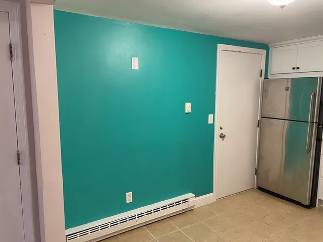 a living room with stainless steel appliances granite countertop white cabinets and a stove top oven
