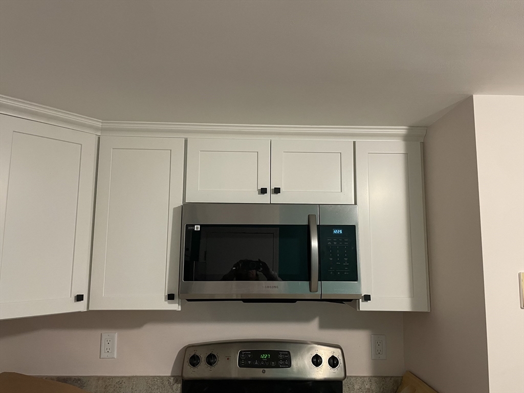 870 Haverhill Street, Unit 2B Rowley, MA 01969 - Photo 14 of 21 a living room with stainless steel appliances granite countertop white cabinets and a stove top oven