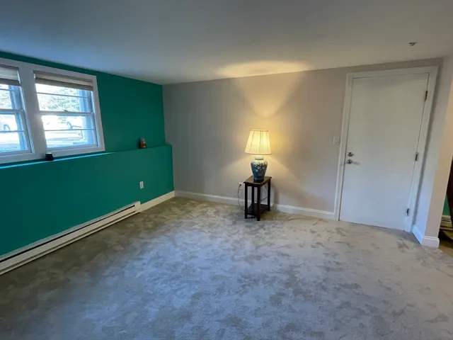 a view of an empty room with window and stairs