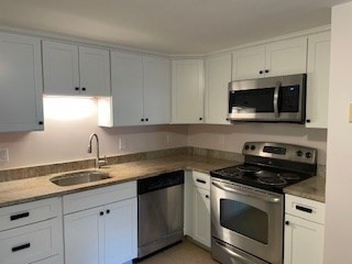 870 Haverhill Street, Unit 2B Rowley, MA 01969 - Photo 2 of 21 a kitchen with granite countertop white cabinets white stainless steel appliances and a sink