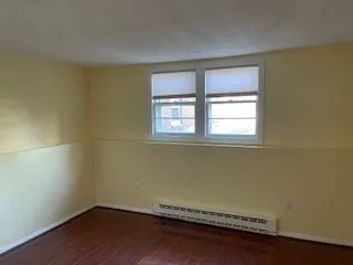 a view of a room with wooden floor and a window