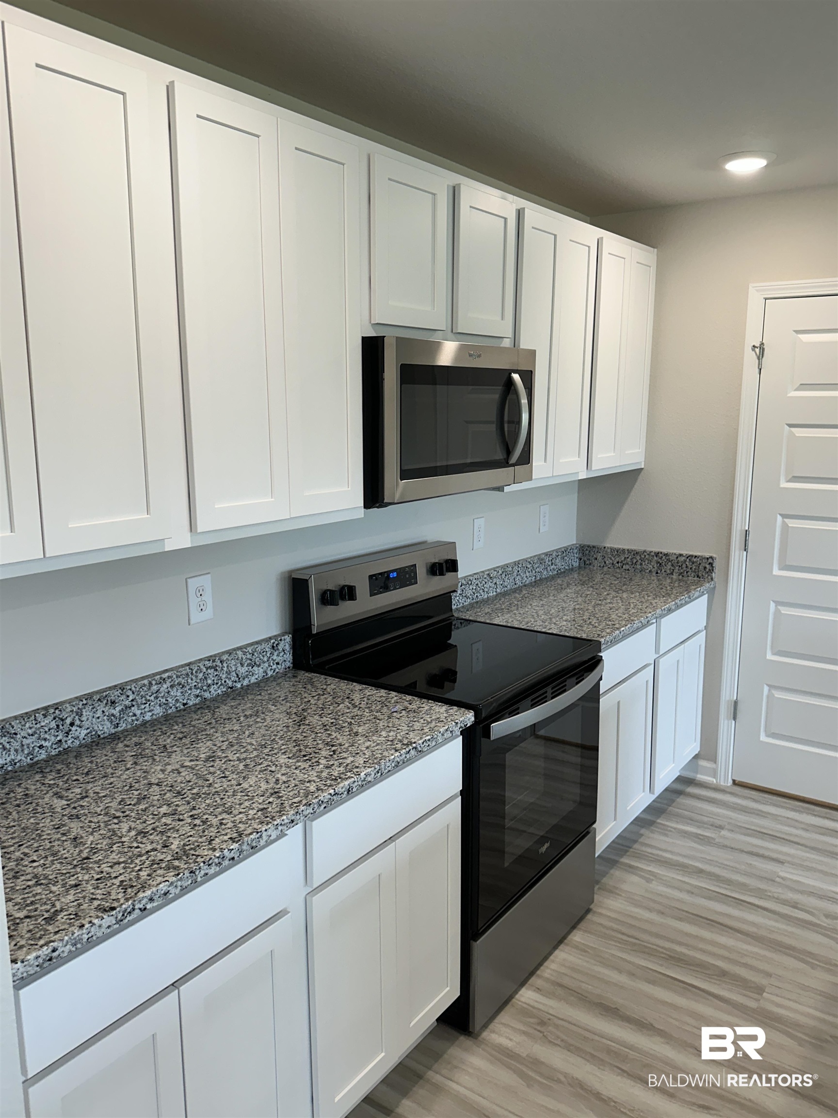8850 Sea Star Circle Foley, AL 36535 - Photo 19 of 29 Kitchen with light wood-type flooring, white cabinets, and stainless steel appliances