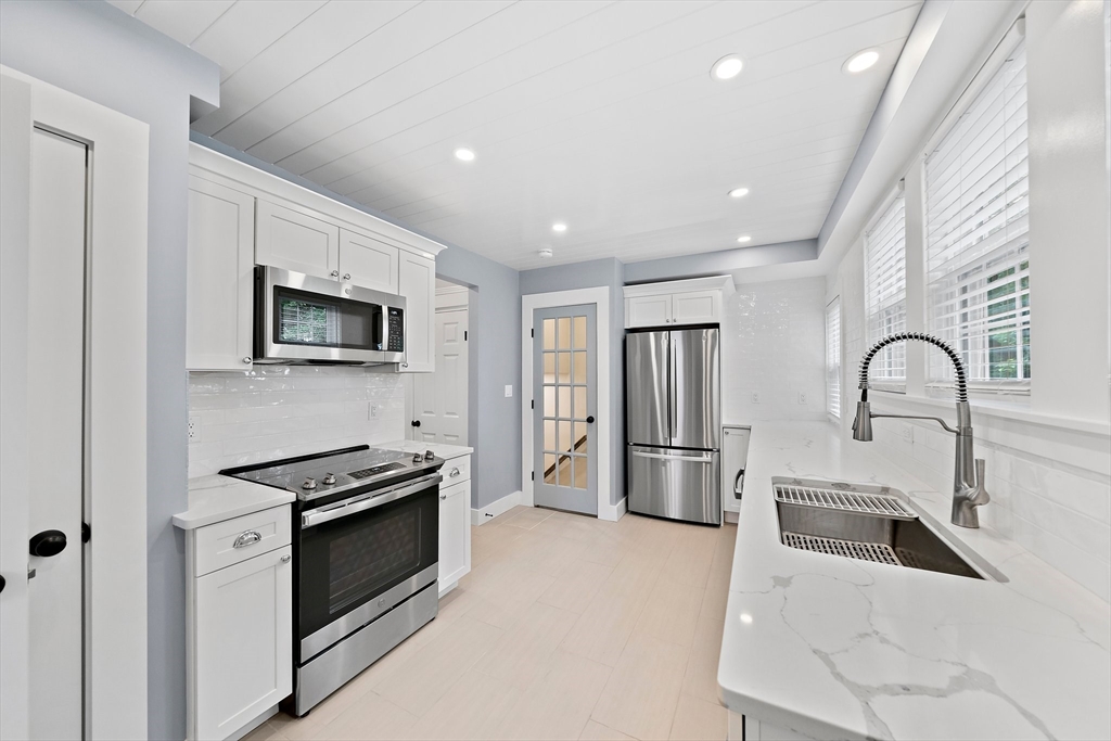 37 Wolcott Road, Unit 37 Brookline, MA 02467 - Photo 12 of 40 a kitchen with stainless steel appliances a stove microwave and sink