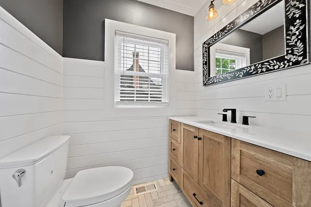 a bathroom with a sink a toilet and a window