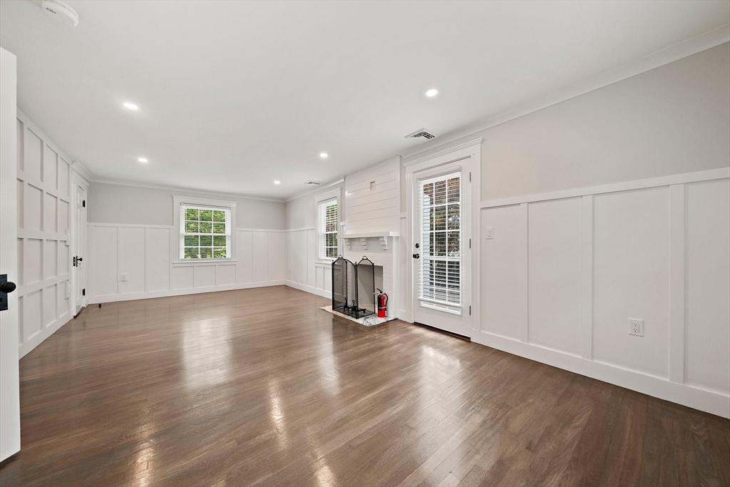 37 Wolcott Road, Unit 37 Brookline, MA 02467 - Photo 15 of 40 an empty room with wooden floor fireplace and windows