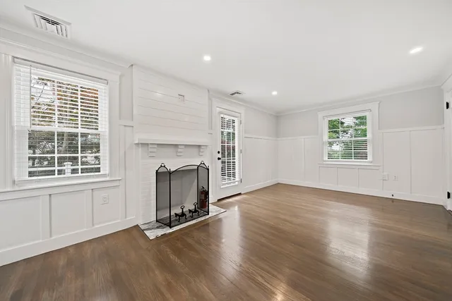 an empty room with wooden floor and fireplace