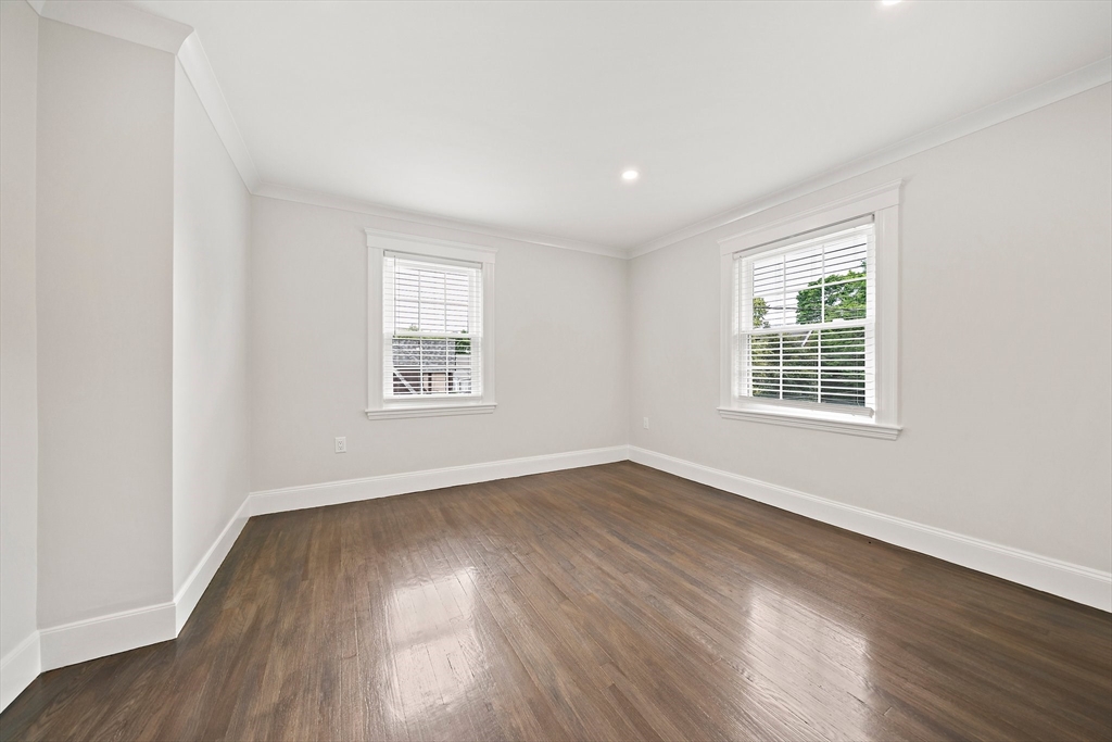 37 Wolcott Road, Unit 37 Brookline, MA 02467 - Photo 19 of 40 a view of an empty room with wooden floor and a window