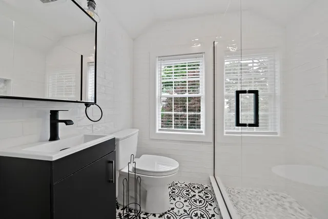 a bathroom with a toilet a sink and mirror