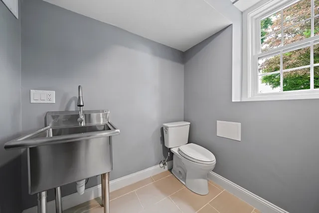 a bathroom with a toilet a sink and a window