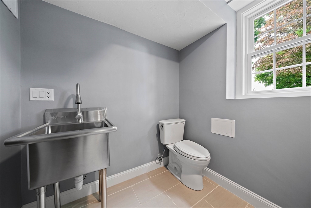 37 Wolcott Road, Unit 37 Brookline, MA 02467 - Photo 33 of 40 a bathroom with a toilet a sink and a window