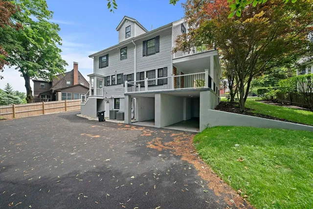 a view of a house with a yard and large tree