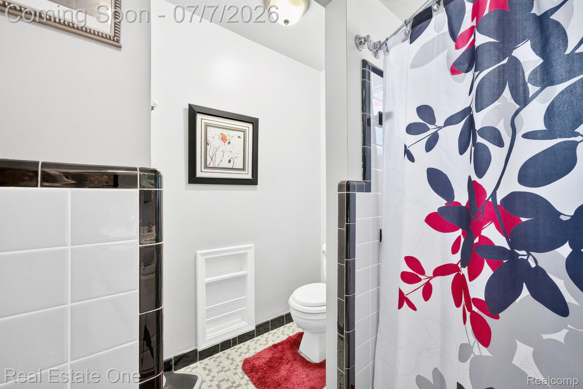 24749 Munson Street Taylor, MI 48180 - Photo 11 of 28 Bathroom featuring white wall tile with black trim, mosaic floor tile, and a built-in wall shelf