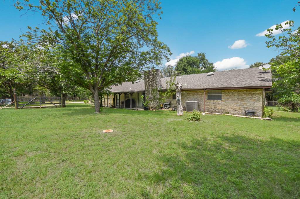 301 Navajo Trail Georgetown, TX 78633 - Photo 16 of 35 Rear view of property with central air condition unit, a chimney, and roof with shingles