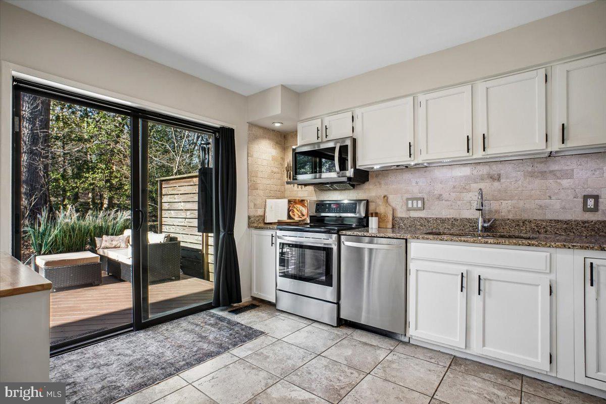 11514 Sunder Court Reston, VA 20190 - Photo 15 of 81 a kitchen with granite countertop a stove top oven sink and cabinets