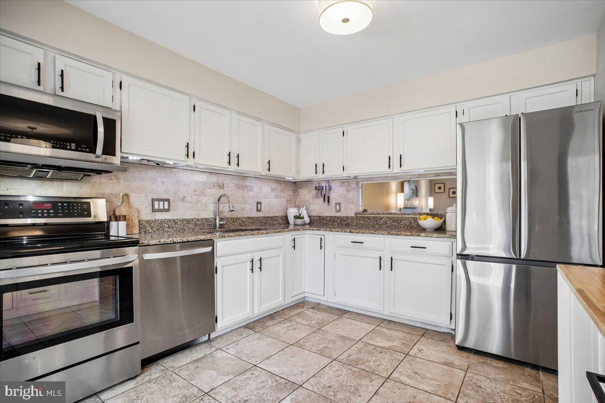 11514 Sunder Court Reston, VA 20190 - Photo 16 of 81 a kitchen with granite countertop white cabinets and stainless steel appliances