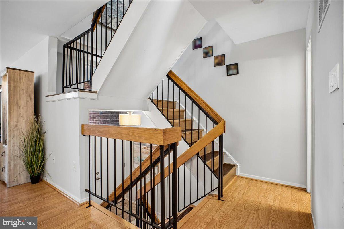 11514 Sunder Court Reston, VA 20190 - Photo 20 of 81 a view of staircase with lots of frames on wall and wooden floor