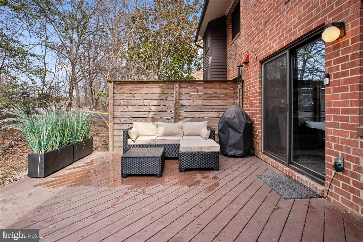 11514 Sunder Court Reston, VA 20190 - Photo 51 of 81 a view of a patio with couches and table and chairs with wooden floor and fence