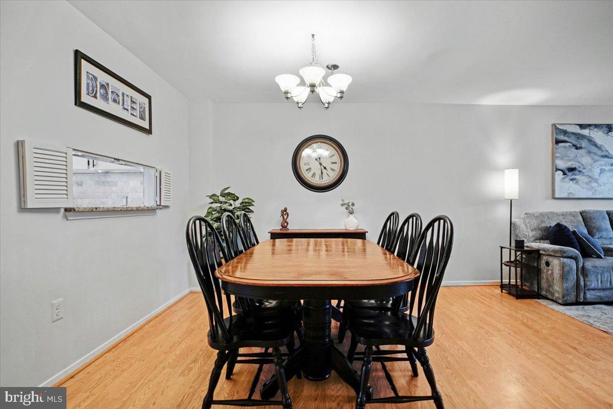 11514 Sunder Court Reston, VA 20190 - Photo 10 of 81 a view of a dining room with furniture a chandelier and wooden floor