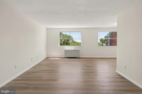 an empty room with wooden floor and window