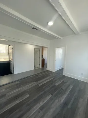 a view of empty room with wooden floor and window