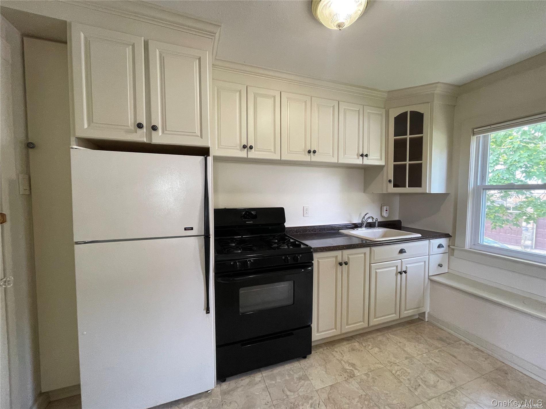 293 West Shore Road, Unit 4 Huntington, NY 11743 - Photo 5 of 13 a kitchen with stainless steel appliances granite countertop a refrigerator stove a sink and dishwasher with white cabinets