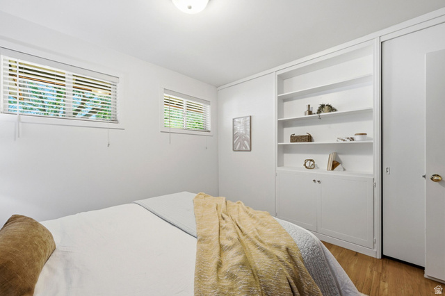 1709 Meadowmoor Road Holladay, UT 84117 - Photo 19 of 32 Recessed lighting illuminates the room, featuring two windows with horizontal blinds, built-in shelving, and wood-finish flooring