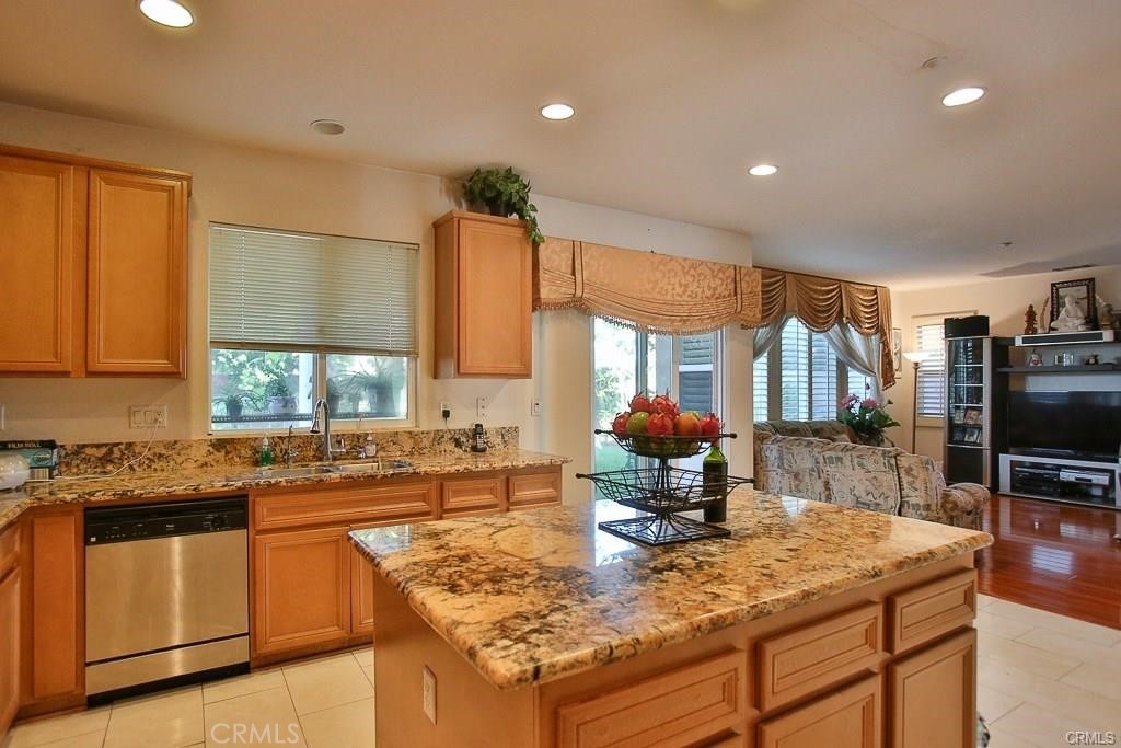 6302 Lavender Way Westminster, CA 92683 - Photo 17 of 38 a kitchen with kitchen island granite countertop a sink stove and cabinets