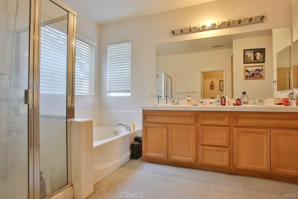 6302 Lavender Way Westminster, CA 92683 - Photo 24 of 38 a bathroom with a double vanity sink a mirror and a bathtub