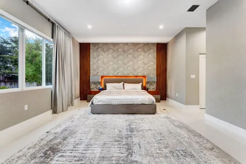 a bedroom with a large bed and a large window