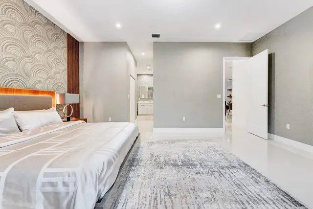 a spacious bedroom with a bed and painting on the wall