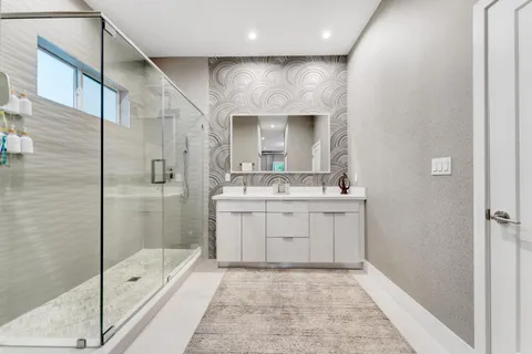 a bathroom with a sink a toilet and shower